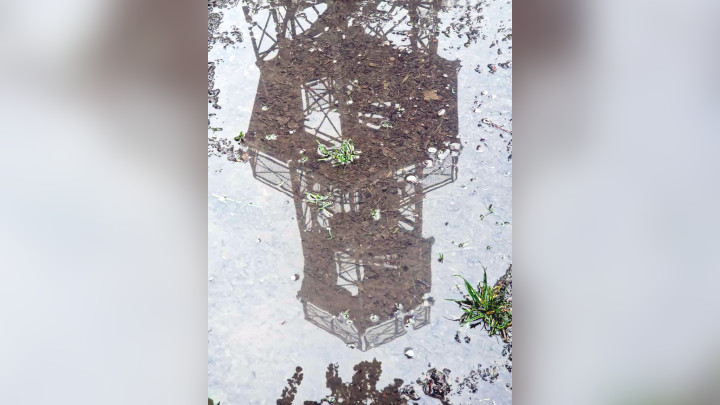 Perfect reflection of the tower in a puddle.